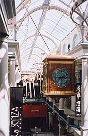 The clock floating above the commerce of the mall.