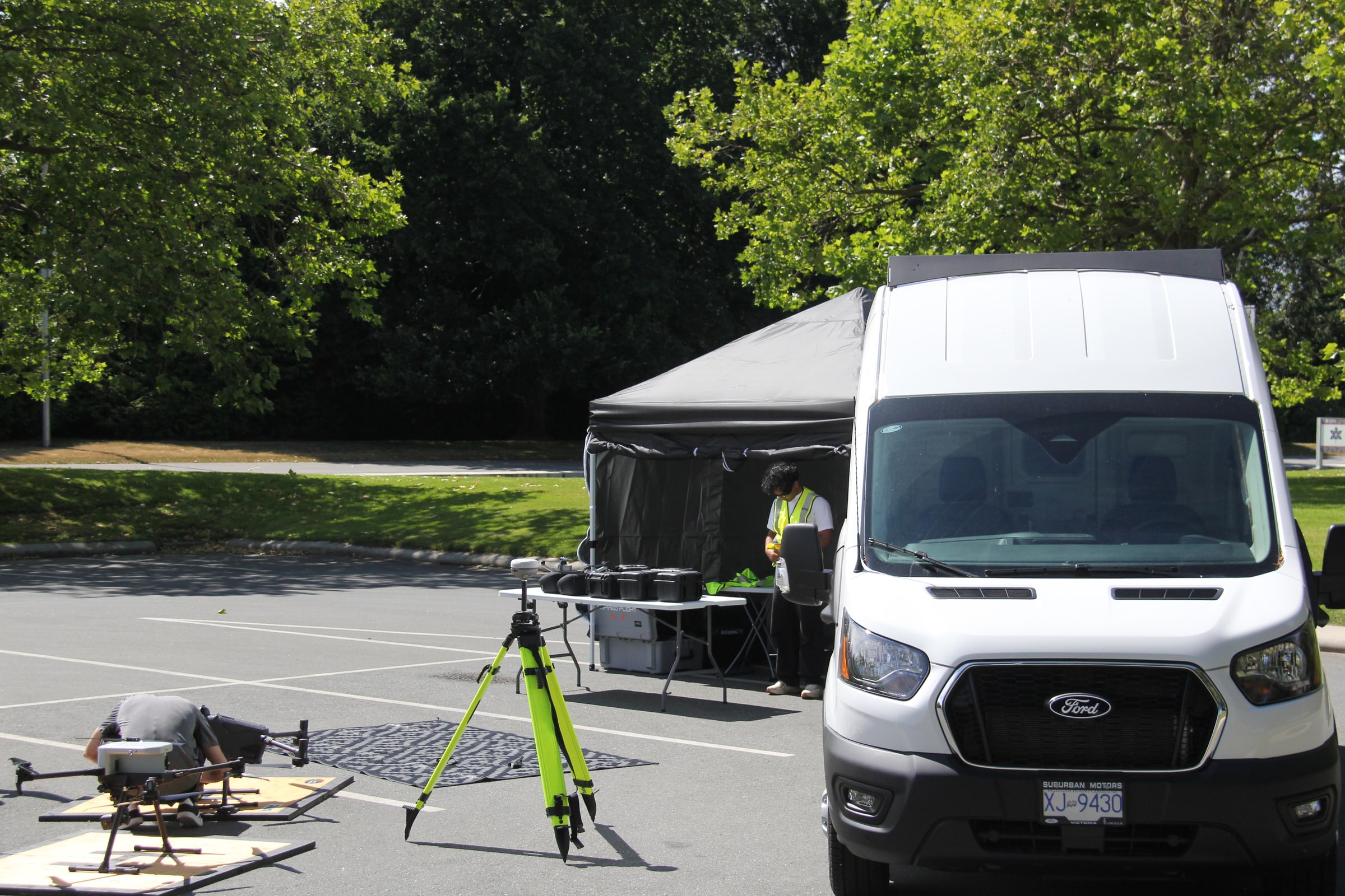 ACIS drone surveying equipment set up beside a field operations van.
